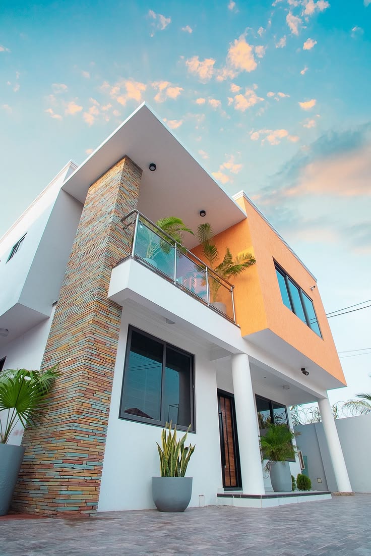 Contemporary residential architecture with stone detailing and planted balconies